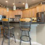 A before image of a kitchen with grey paint and light brown cabinets.