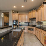 Another angle of the before showing the island with the kitchen sink and black countertops.