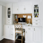 White cabinets that form a built in desk.