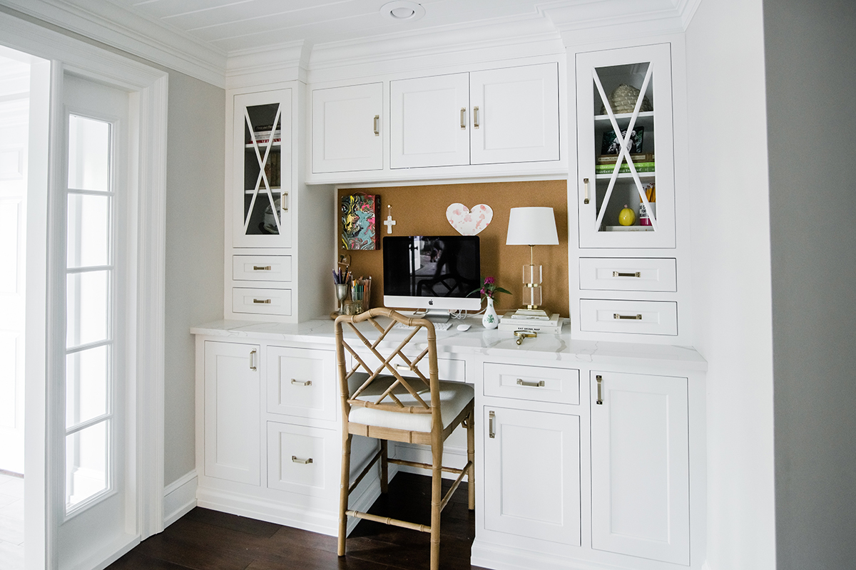 White cabinets that form a built in desk.