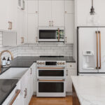 White cabinets, black countertop with shiny gold handles