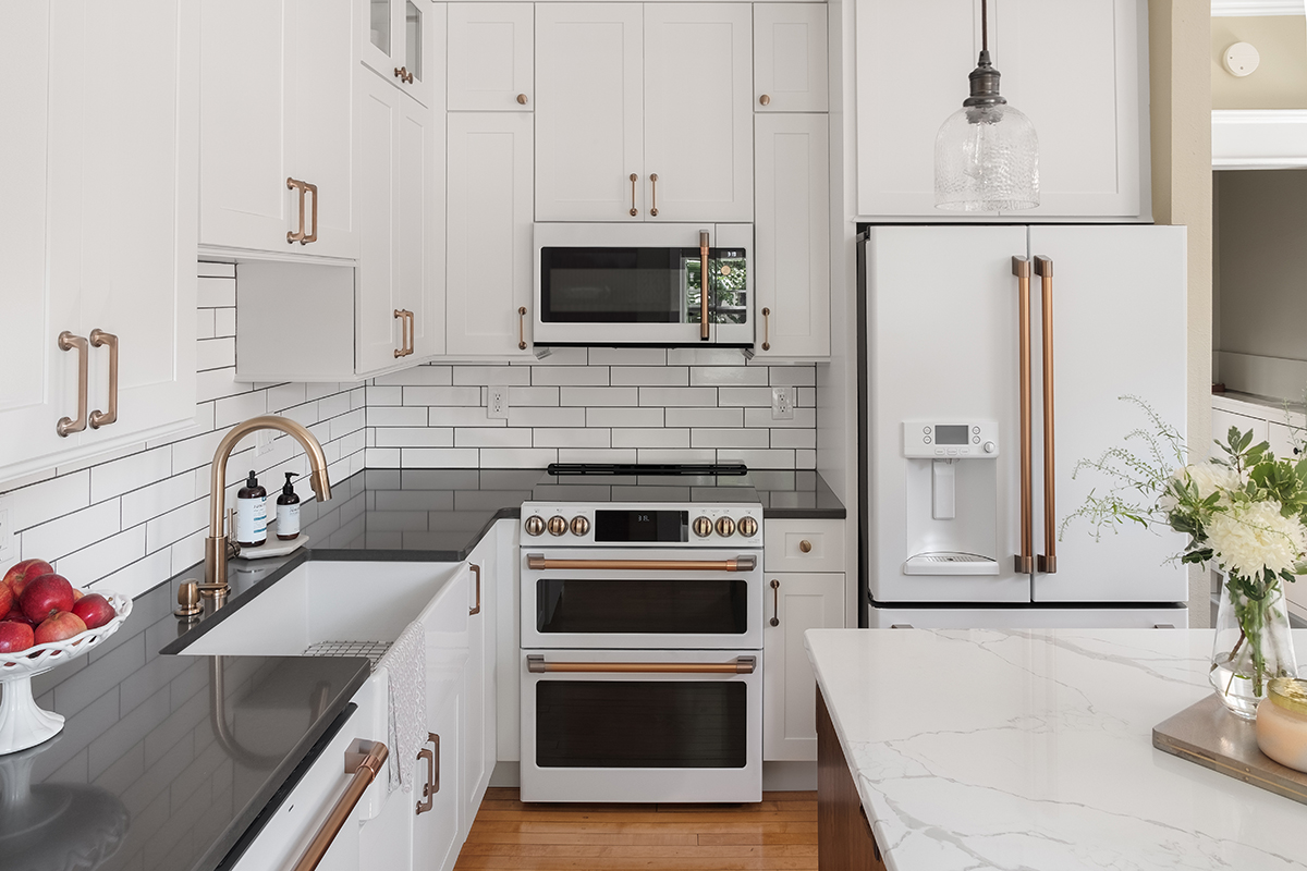 White cabinets, black countertop with shiny gold handles