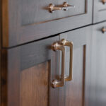 brown cabinets with a focus on the gold handles