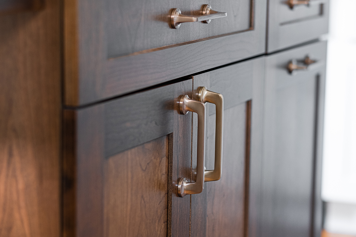 brown cabinets with a focus on the gold handles