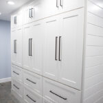 rear side of white mudroom cabinetry. Mudroom cabinets float in the middle of the room.