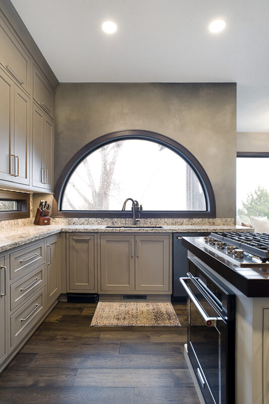 Shows kitchen sink with beige cabinets.