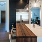 Another view of the walnut bar top that is attached to the island with the white bar stools