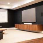 Built in walnut entertainment center below a flat screen tv.