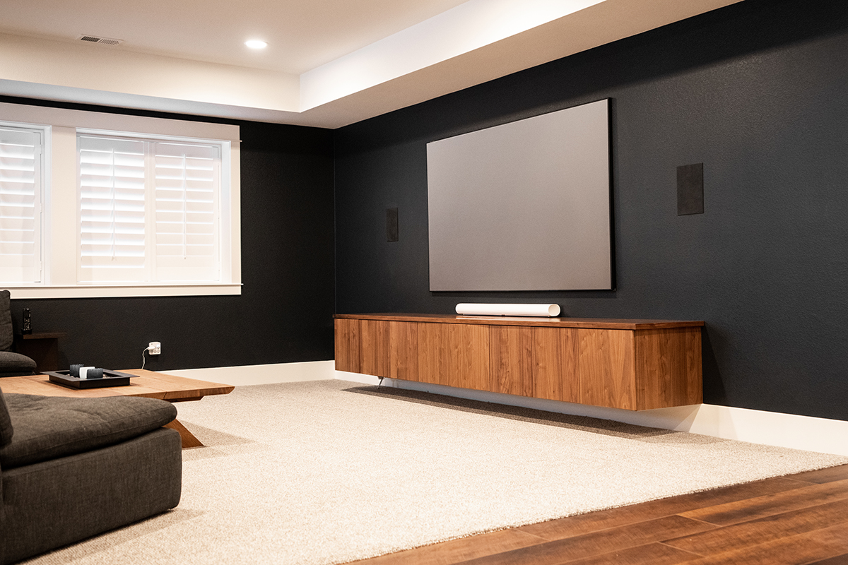 Built in walnut entertainment center below a flat screen tv.