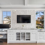 Built in cabinets and the drawers in the office with windows behind the computer monitor.