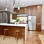 Walnut cabinets with the white countertop. The range and range hood is on the middle island the hood comes out of the ceiling.