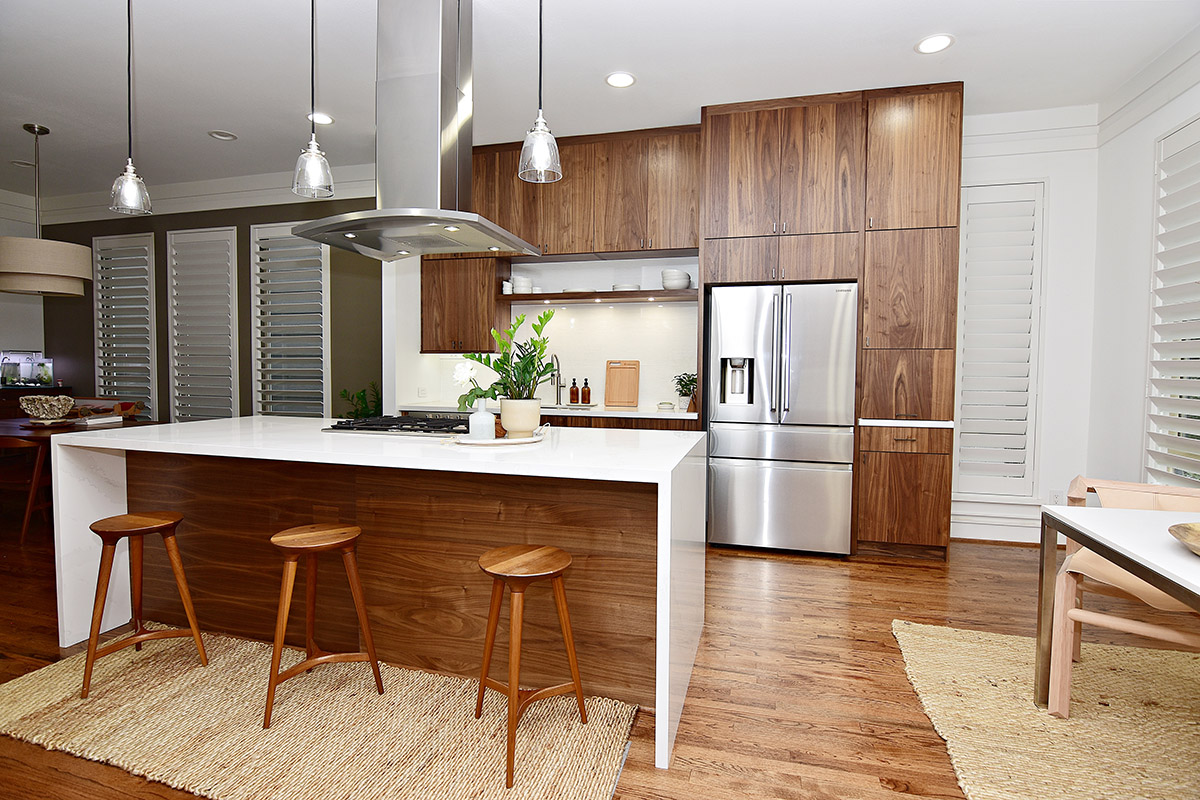 Walnut cabinets with the white countertop. The range and range hood is on the middle island the hood comes out of the ceiling.