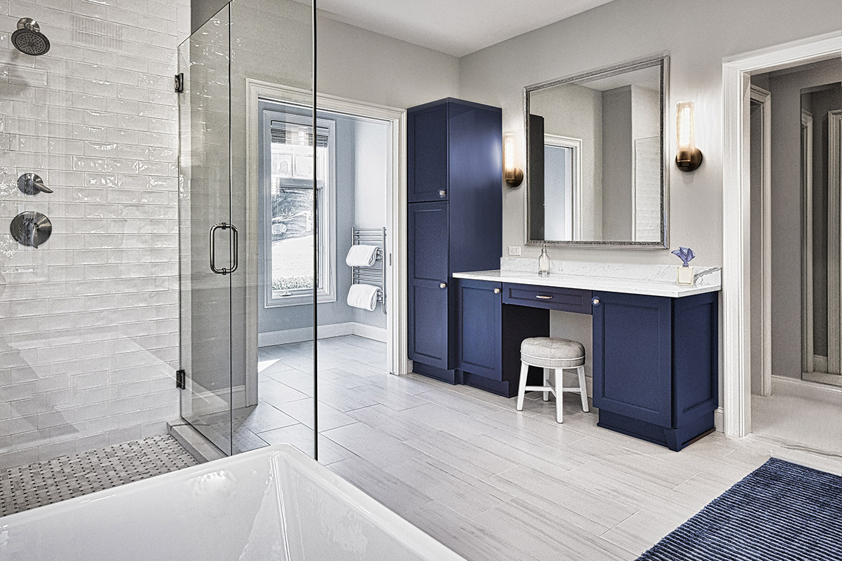 Glass shower view with a makeup vanity and large mirror.