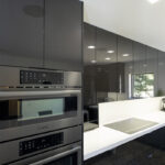 Dark grey cabinets close up of ovens that are built into the wall.