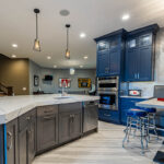 A view of the grey cabinets paired with the blue cabinets along the wall. We also see the built-in booth.