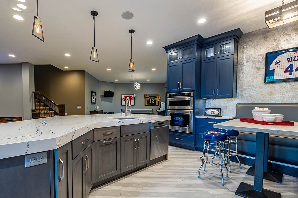 A view of the grey cabinets paired with the blue cabinets along the wall. We also see the built-in booth.