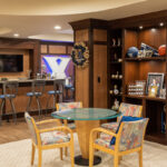 Shows the sports bar in the basement with a round table.