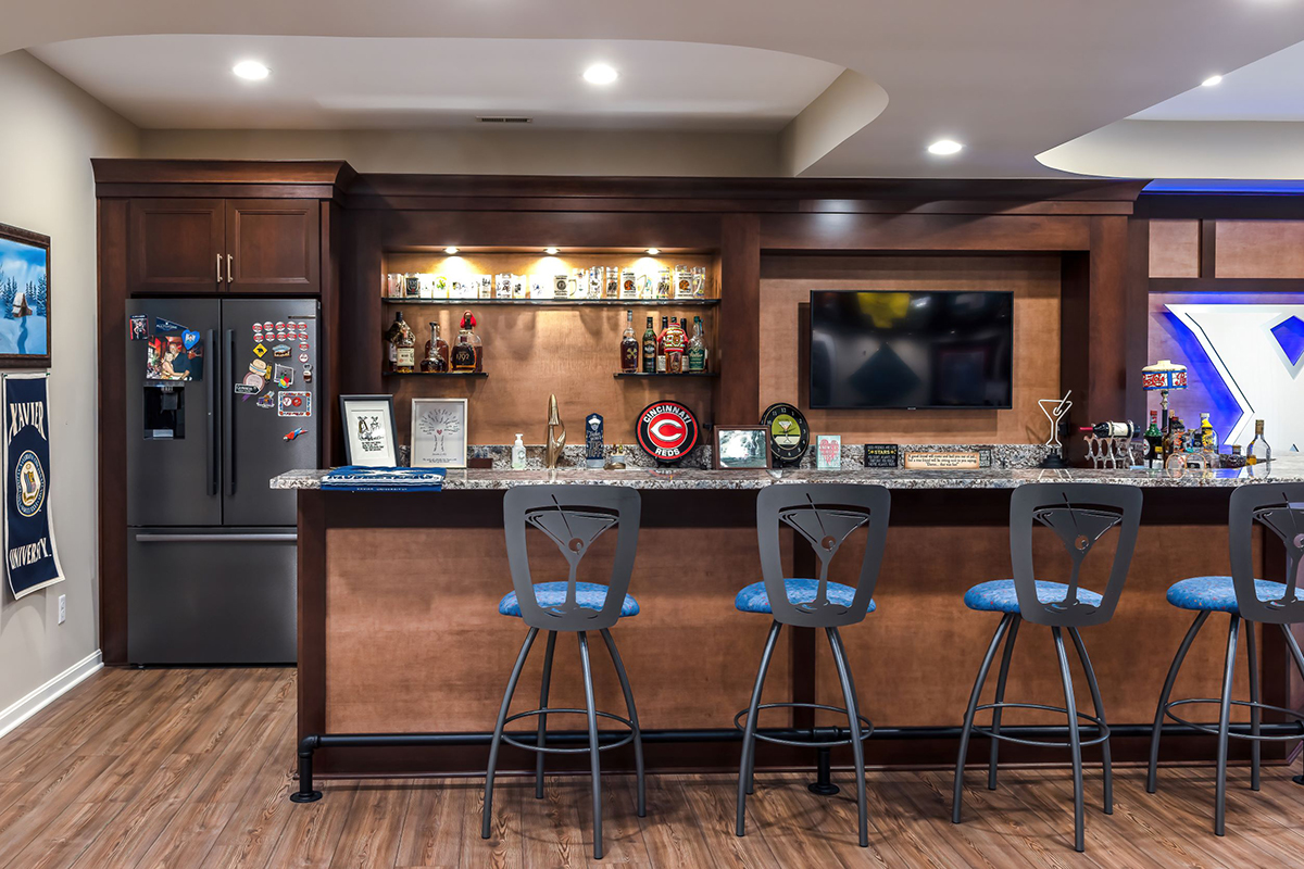 Wide view of the bar with the bar stools. We see the details of the dual toned wood features of the house.