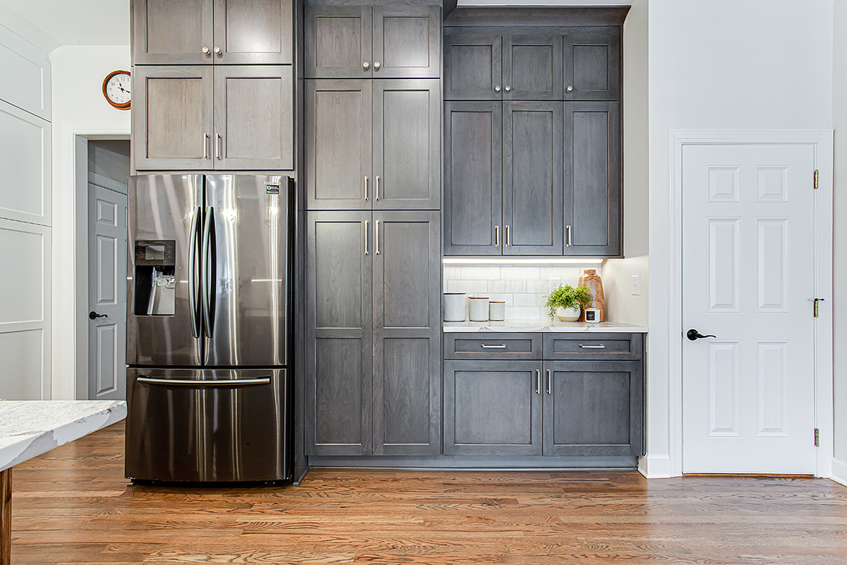Shows the fridge and large pantry cabinets that are floor to ceiling.