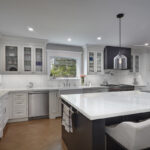 An opposing long view of the kitchen that shows the dishwasher next to the sink.