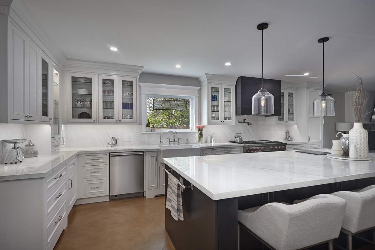 An opposing long view of the kitchen that shows the dishwasher next to the sink.