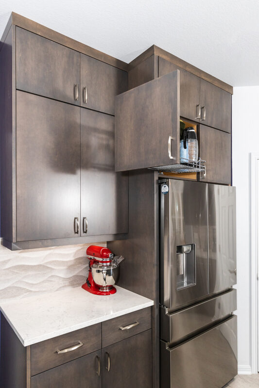 small coffee nook next to fridge in kitchen cabinetry
