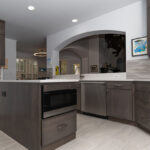 large cutout in wall opening up to brown kitchen cabinetry and appliances