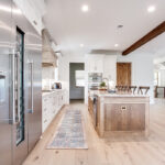 This photo shows the length of the kitchen. The large commercial fridge is to the left with the hickory island as the center point of the kitchen.