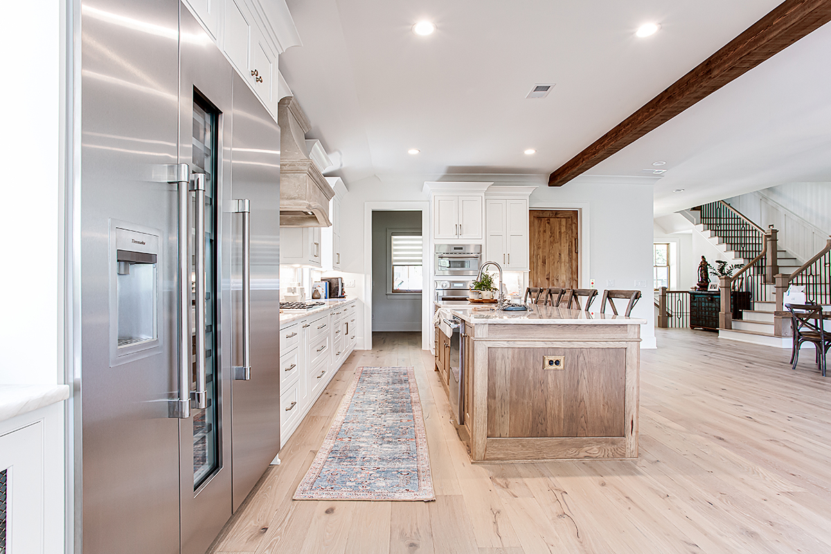 This photo shows the length of the kitchen. The large commercial fridge is to the left with the hickory island as the center point of the kitchen.