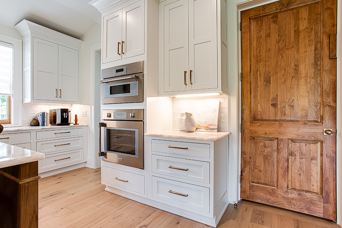 Double ovens are built-in to the walls. We see the gold hardware more prominently.