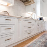Up-close view of the handles and the face of the lower white cabinets
