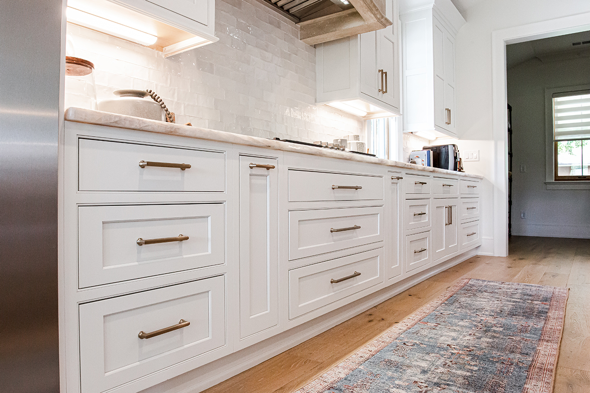 Up-close view of the handles and the face of the lower white cabinets