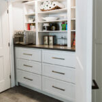 Built-in storage cabinets and coffee shelf within the pantry closet.