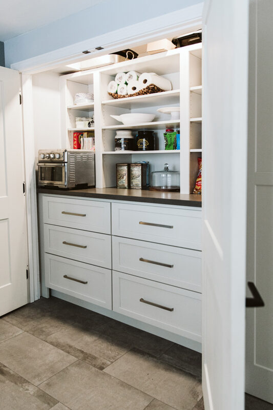 Built-in storage cabinets and coffee shelf within the pantry closet.
