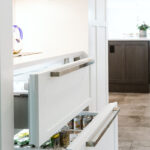 A photo of the beverage drawer and the ice chest drawer above it. Both drawers have the same white kitchen cabinet face and silver handle.