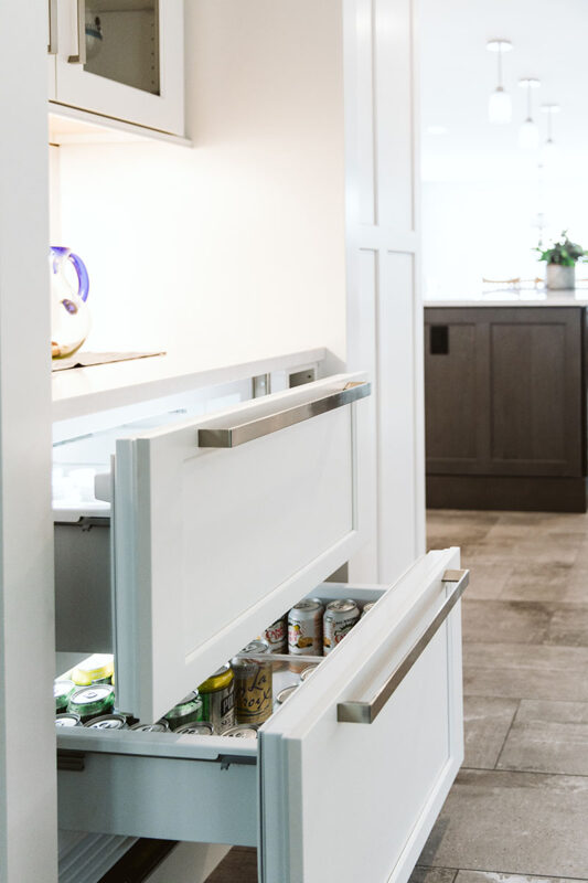 A photo of the beverage drawer and the ice chest drawer above it. Both drawers have the same white kitchen cabinet face and silver handle.