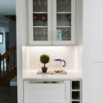 Shows lower cabinets with wine storage next to the cabinets. The drawers are the beverage cooler and the ice chest. Above these there are glass-faced cabinets.