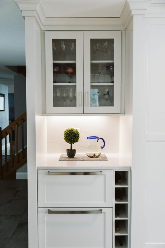Shows lower cabinets with wine storage next to the cabinets. The drawers are the beverage cooler and the ice chest. Above these there are glass-faced cabinets.