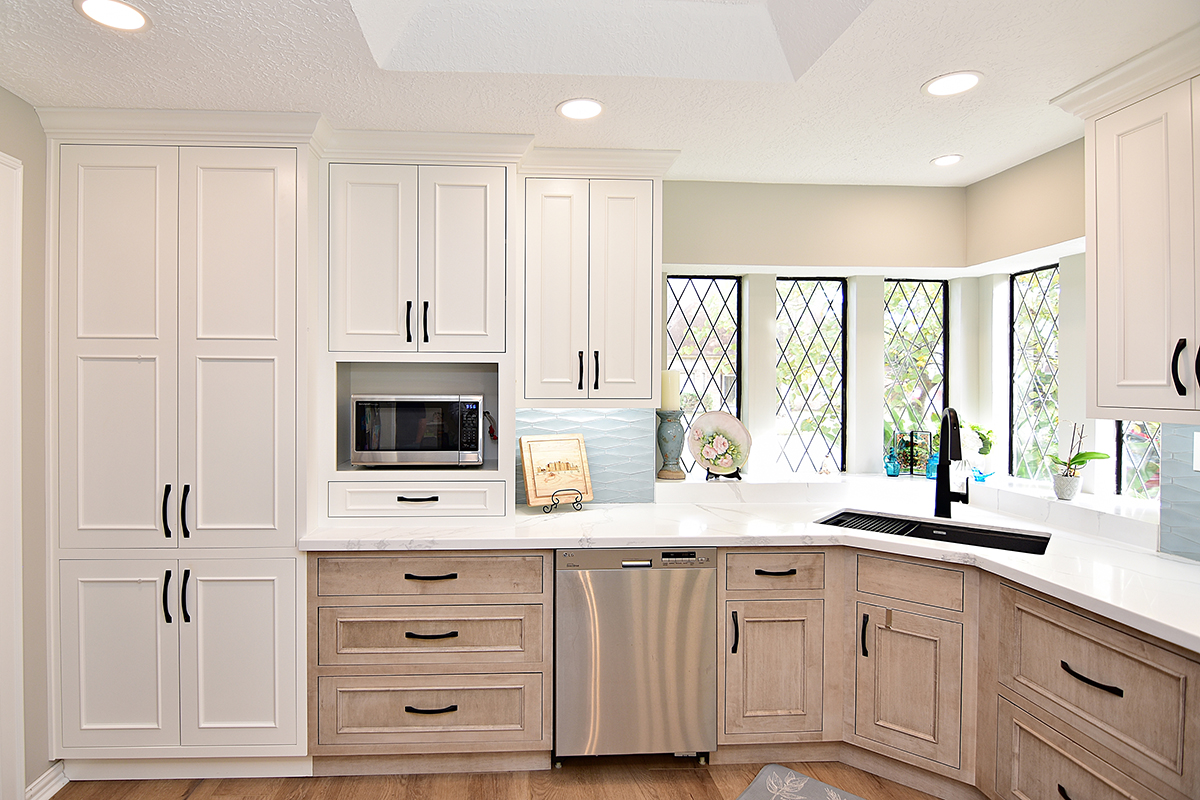 Another view of the corner of the kitchen, floor-to-ceiling pantry, microwave cove, under the counter dishwasher, and corner sink.