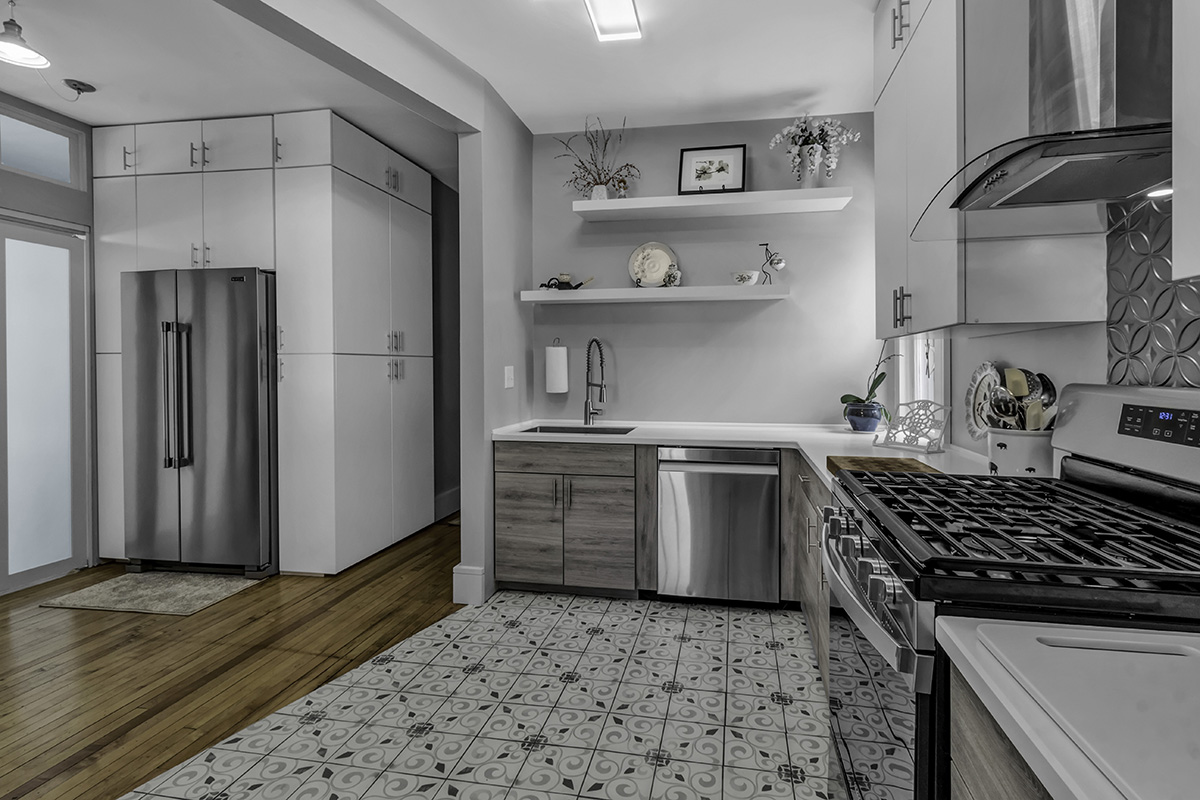 white and gray kitchen with wood and tile flooring. Stainless steel appliances and gray walls.