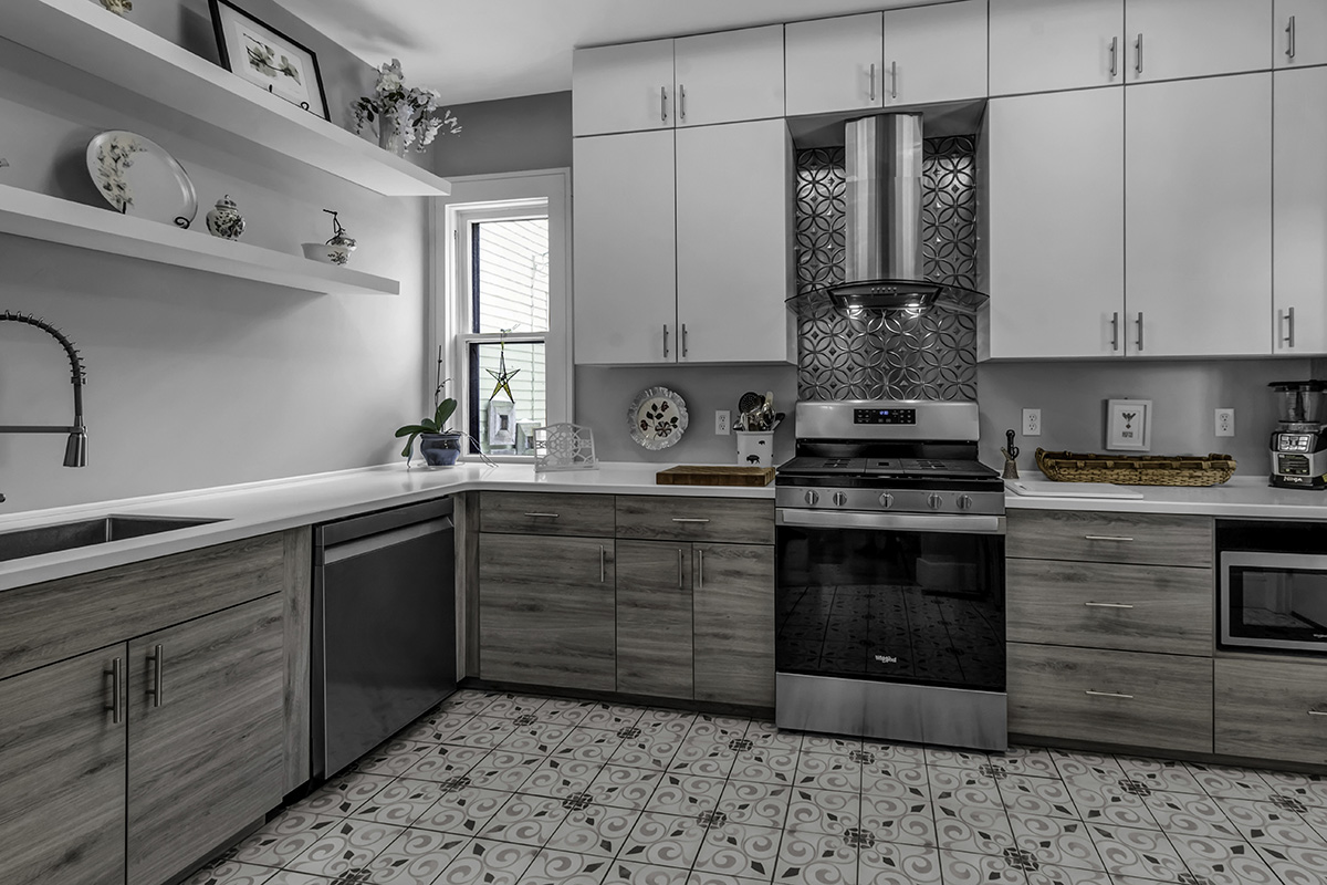 small city kitchen with gray upper cabinetry. Stone countertops sit on gray brushed wood cabinetry.