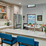 natural colored kitchen with white cabinets and blue island chairs.
