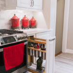 Beside the stove there is a pull-out drawer that holds cooking tools and cooking oil.