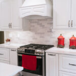 Photo featuring the stove and gas range with the white range hood.