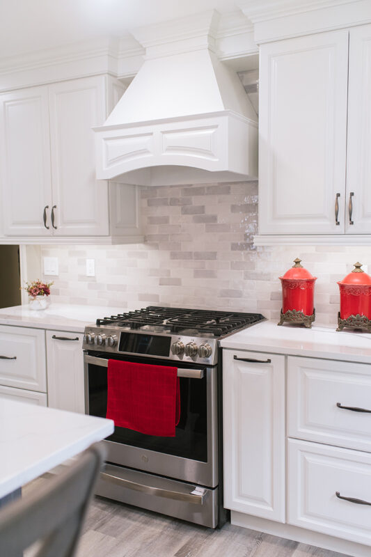 Photo featuring the stove and gas range with the white range hood.