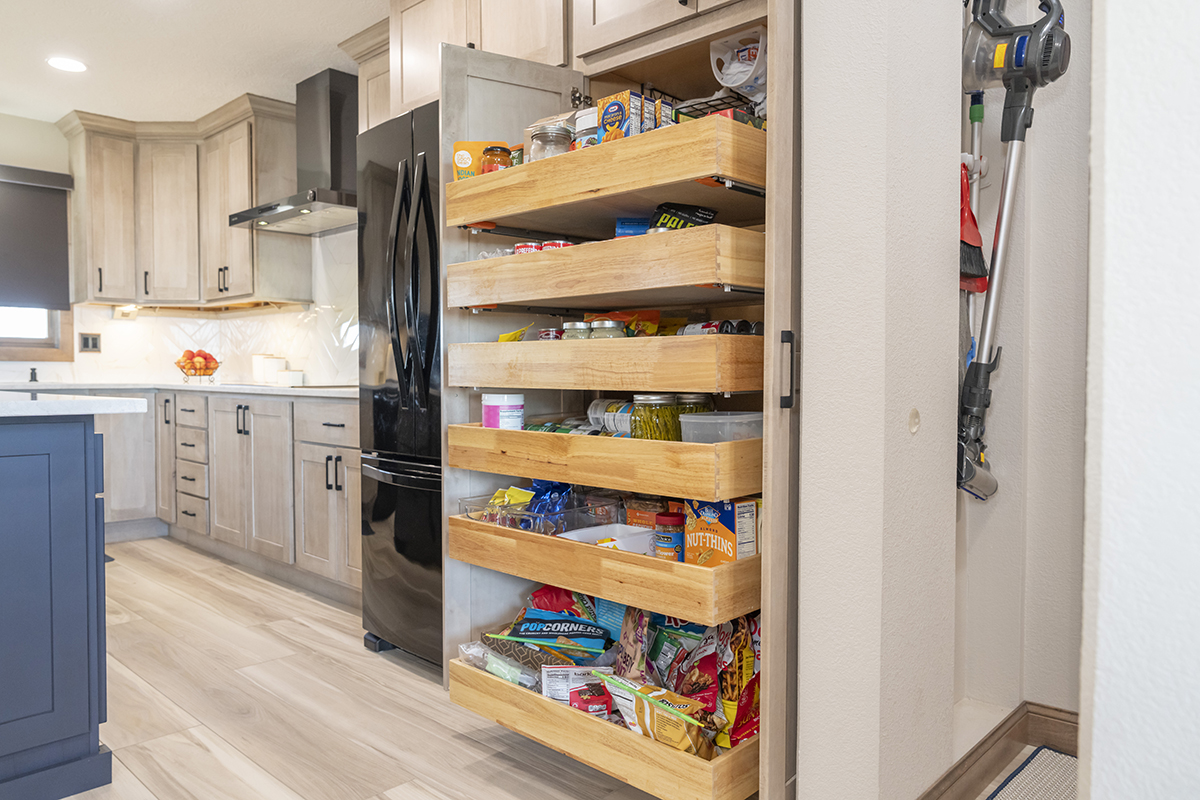 soft and smooth kitchen cabinetry is open, to show pantry full of food and snacks.