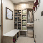 mudroom storage area with brown cabinetry. Shoes are conveniently stored throughout, with extra locker space to the side.