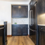 Another view of the alley between the external wall of the kitchen and the island. This gives a clearer view of the light grey herringbone backsplash.