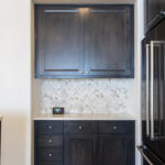 Another view of the black cabinets and the light grey herringbone backsplash.