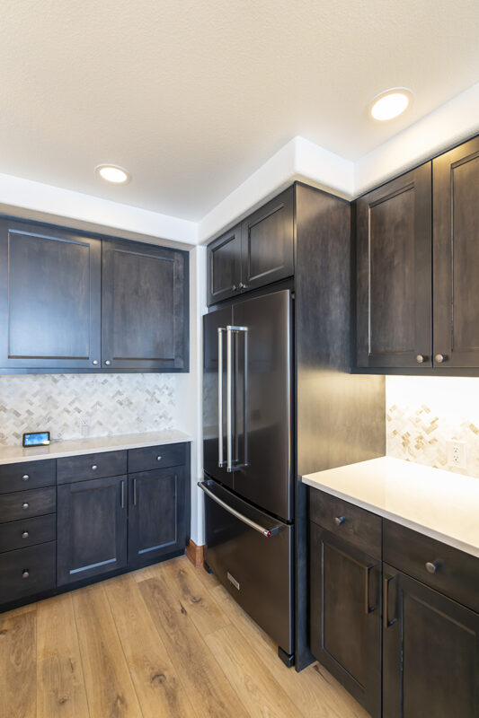 The corner of the kitchen contains a large double door fridge that has a pull-out freezer at the base of it. This offers another view of the floor to ceiling cabinets that cap the end of the kitchen.
